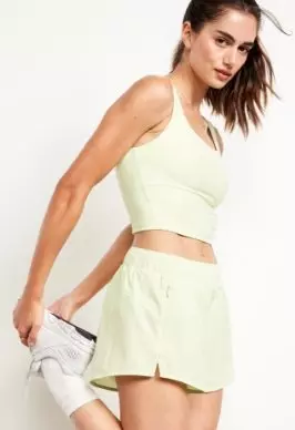 A female model wears Mid-Rise StretchTech Run Shorts -- 3-inch inseam.